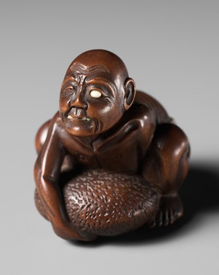 GYOKKEI: A WOOD NETSUKE OF A BLIND MAN LIFTING A CHIKARAISHI