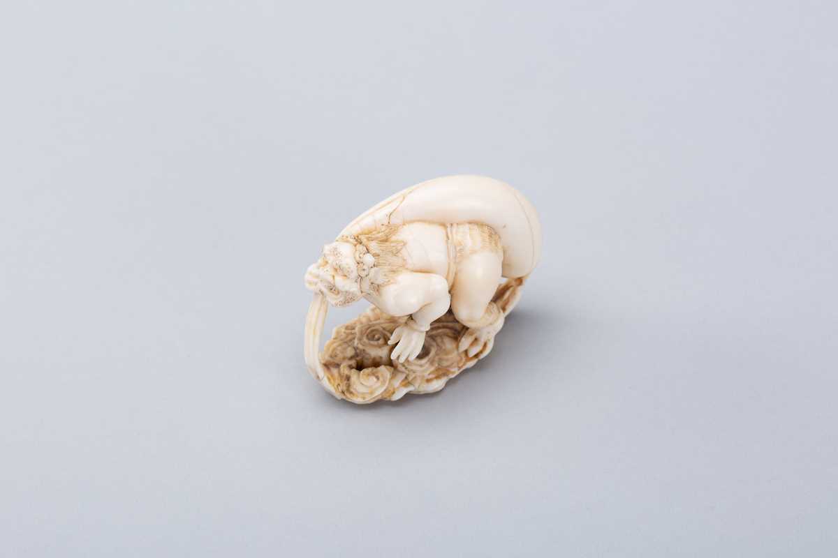 Lot 721 - A MARINE IVORY NETSUKE-OKIMONO OF FUJIN