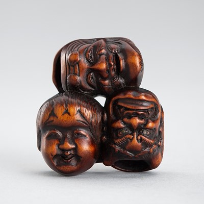 Lot 595 - GYOKUZAN: A WOOD NETSUKE OF A CLUSTER OF SIX MASKS