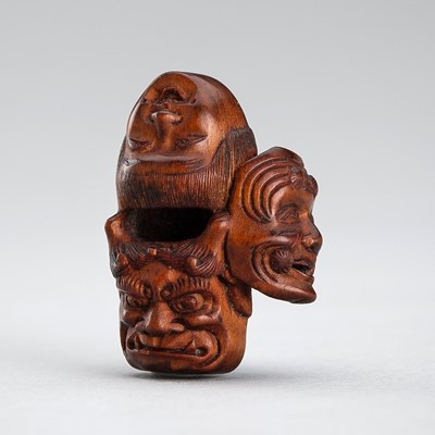 Lot 606 - GYOKUZAN: A WOOD NETSUKE OF A CLUSTER OF FOUR MASKS