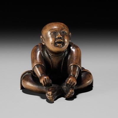 Lot 167 - A CHARMING EDO SCHOOL WOOD NETSUKE OF A SEATED BOY