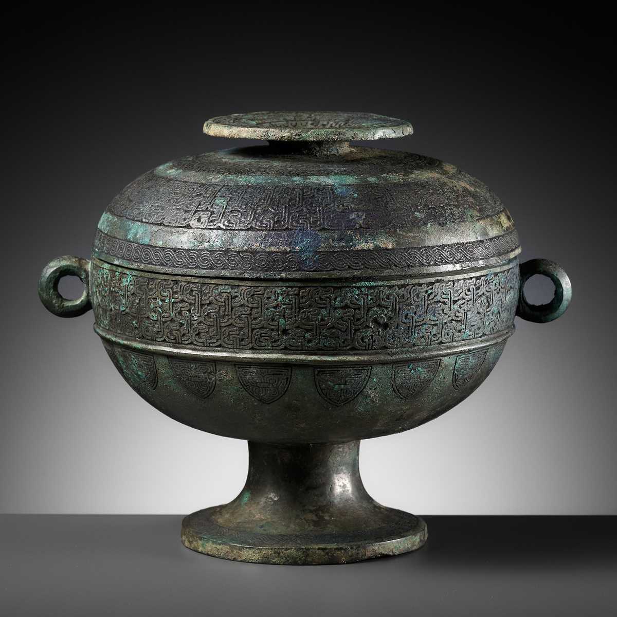 Lot 64 - AN ARCHAIC BRONZE RITUAL FOOD VESSEL AND COVER, DOU, WITH ELEVEN BANDS OF DECORATION, LATE SPRING AND AUTUMN TO EARLY WARRING STATES PERIOD