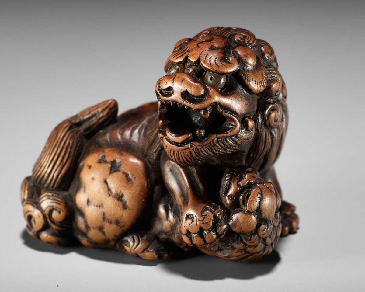 Lot 124 - A FINE TANBA SCHOOL WOOD NETSUKE OF A SHISHI WITH YOUNG