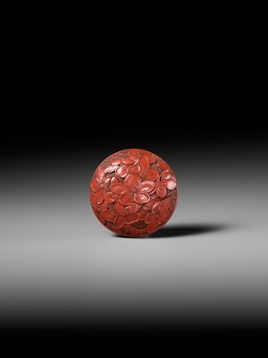 Lot 288 - A FINE TSUISHU (CARVED RED LACQUER) MANJU NETSUKE WITH PEACH BLOSSOMS