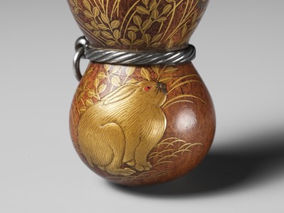Lot 432 - A FINE AND LARGE LACQUERED GOURD NETSUKE WITH A CHUBBY HARE AMONGST AUTUMN GRASSES