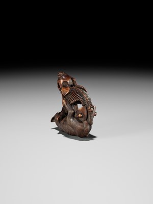 Lot 98 - A FINE WOOD NETSUKE OF A WOLF AND SKELETON, ATTRIBUTED TO SHOKO SUGONOYA