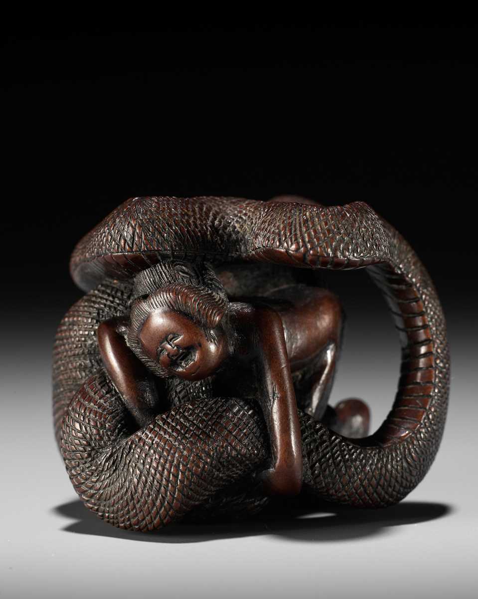 A VERY RARE SHUNGA WOOD NETSUKE OF A NAKED WOMAN AND