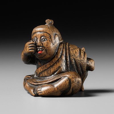 Lot 437 - MIWA: A WOOD NETSUKE OF A BOY HIDING A HANYA MASK