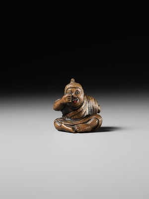 Lot 437 - MIWA: A WOOD NETSUKE OF A BOY HIDING A HANYA MASK