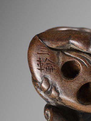 Lot 437 - MIWA: A WOOD NETSUKE OF A BOY HIDING A HANYA MASK