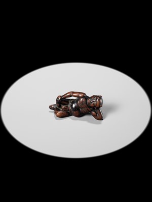 A RARE WOOD NETSUKE OF A RECLINING ONI