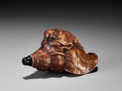 Lot 18 - A WOOD NETSUKE OF BENKEI SLEEPING ON A CONCH (HORAGAI)