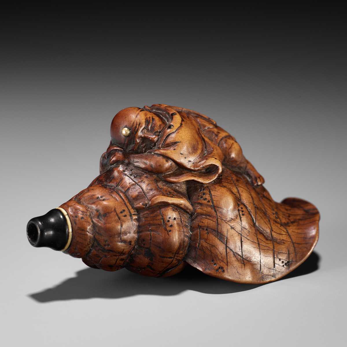 Lot 18 - A WOOD NETSUKE OF BENKEI SLEEPING ON A CONCH (HORAGAI)