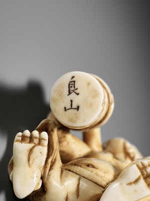 Lot 500 - RYOZAN: AN AMUSING IVORY NETSUKE OF AN ONI CARRYING A BONSHO AND CHOCHIN, CHOCHIN NI TSURIGANE