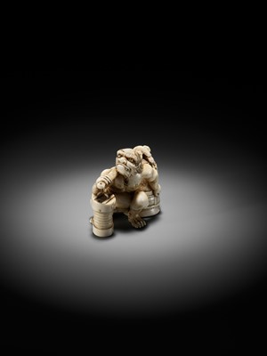 Lot 500 - RYOZAN: AN AMUSING IVORY NETSUKE OF AN ONI CARRYING A BONSHO AND CHOCHIN, CHOCHIN NI TSURIGANE