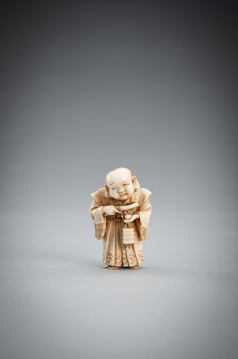Lot 587 - TOMOKAZU: A FINE IVORY NETSUKE OF FUKUSUKE INSPECTING A NETSUKE ATTACHED TO AN INRO