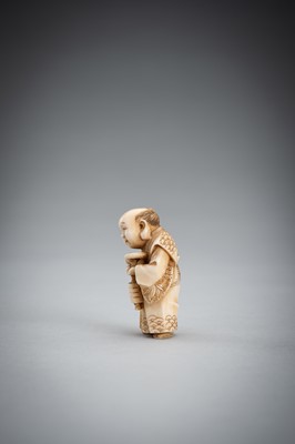 Lot 587 - TOMOKAZU: A FINE IVORY NETSUKE OF FUKUSUKE INSPECTING A NETSUKE ATTACHED TO AN INRO