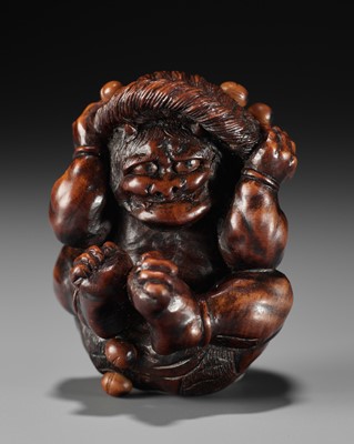 Lot 538 - A FINE WOOD NETSUKE OF AN ONI COWERING DURING SETSUBUN, AFTER TADATOSHI