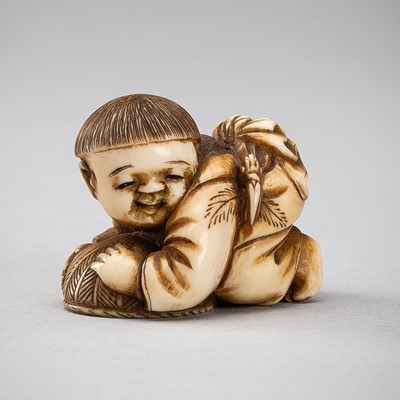 Lot 591 - KOZAN: AN IVORY NETSUKE OF A PLAYING KARAKO