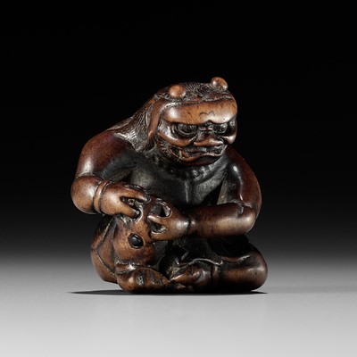 Lot 195 - A POWERFUL WOOD NETSUKE OF AN ONI APPLYING MOXA