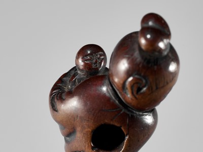 A WOOD NETSUKE OF KAKKYO’S WIFE AND CHILD