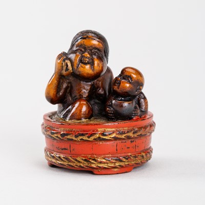 Lot 583 - A WOOD AND NEGORO LACQUER NETSUKE OF A MOTHER AND CHILD TAKING A BATH