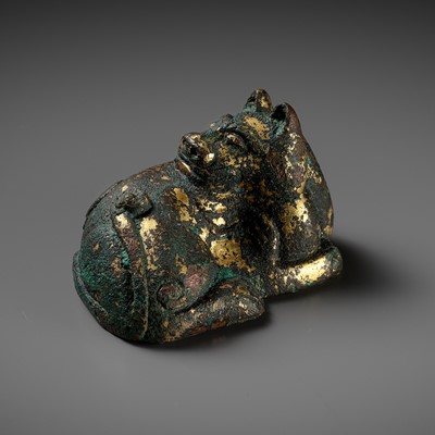 A RARE GILT-BRONZE MAT WEIGHT IN THE FORM OF A DOG, HAN DYNASTY