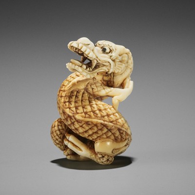 Lot 410 - AN IVORY NETSUKE OF A COILED DRAGON