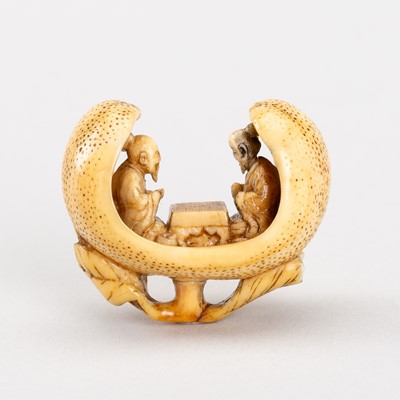 Lot 572 - A FINE IVORY NETSUKE OF GO PLAYERS SEATED INSIDE A PEACH