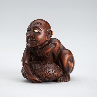 Lot 578 - HOJITSU: A FINE WOOD NETSUKE OF A BLIND MASSEUR LIFTING A CHIKARAISHI