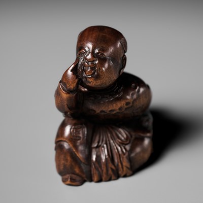 Lot 475 - A CHARMING INLAID WOOD NETSUKE OF A KARAKO BOY HIDING AN OKAME MASK