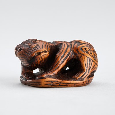 Lot 516 - A RARE WOOD NETSUKE OF A SHISHI ON A COIN