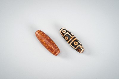 Lot 1517 - A LOT WITH TWO TIBETAN AGATE DZI BEADS, 18TH CENTURY OR EARLIER