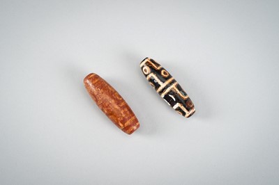 Lot 1517 - A LOT WITH TWO TIBETAN AGATE DZI BEADS, 18TH CENTURY OR EARLIER