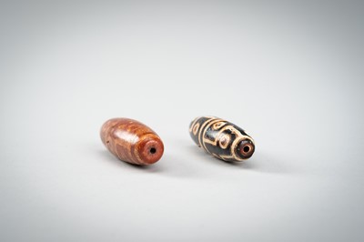 Lot 1517 - A LOT WITH TWO TIBETAN AGATE DZI BEADS, 18TH CENTURY OR EARLIER