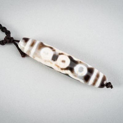 Lot 1518 - A TIBETAN AGATE DZI BEAD NECKLACE, 18TH CENTUR OR EARLIER