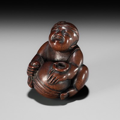 Lot 168 - SHOGYOKU: A WOOD NETSUKE OF A BOY POLISHING A MOKUGYO