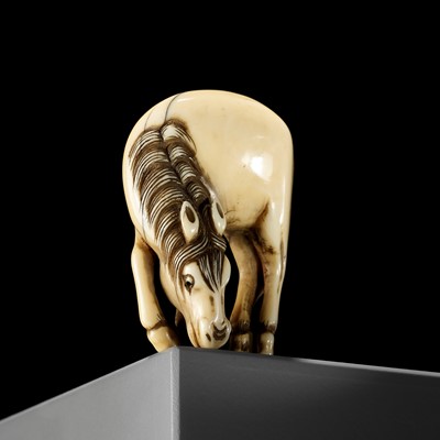 Lot 10 - A FINE IVORY NETSUKE OF A GRAZING HORSE