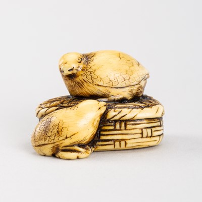 A MARINE IVORY NETSUKE OF A PAIR OF QUAIL ON A MILLET BASKET