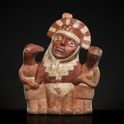 Lot 142 - A CERAMIC STIRRUP-SPOUT VESSEL IN THE FORM OF A PRISONER WITH AVIAN CAPTORS, MOCHE CULTURE