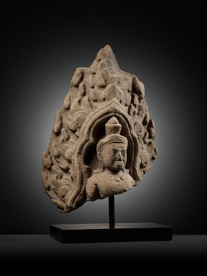 Lot 979 - A SANDSTONE ANTEFIX OF A MALE DEITY, ANGKOR