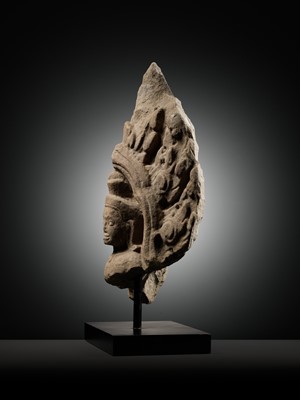 Lot 979 - A SANDSTONE ANTEFIX OF A MALE DEITY, ANGKOR