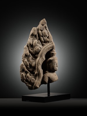 Lot 979 - A SANDSTONE ANTEFIX OF A MALE DEITY, ANGKOR