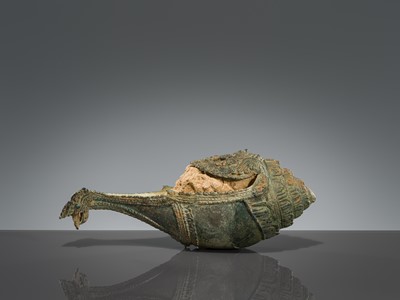 Lot 356 - A BRONZE RITUAL CONCH SHELL WITH A FIGURE OF HEVAJRA WITH YOGINIS, ANGKOR PERIOD, BAYON STYLE