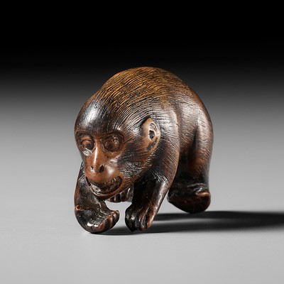 Lot 422 - AN AMUSING WOOD NETSUKE OF A CLIMBING MONKEY