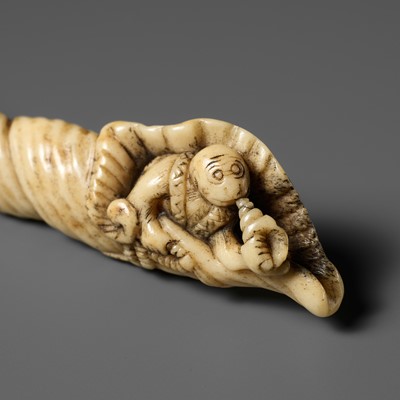 Lot 513 - A RARE ANTLER NETSUKE OF A MONKEY PARODYING BENKEI IN A HORAGAI (CONCH)