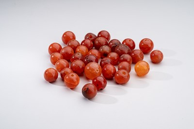 Lot 1155 - A LOT WITH 35 SOUTHEAST ASIAN CARNELIAN AGATE BEADS, 7th – 12th century