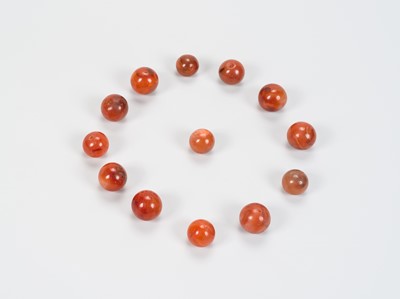 Lot 1157 - A LOT WITH 13 SOUTHEAST ASIAN CARNELIAN AGATE BEADS, 7TH – 12TH CENTURY