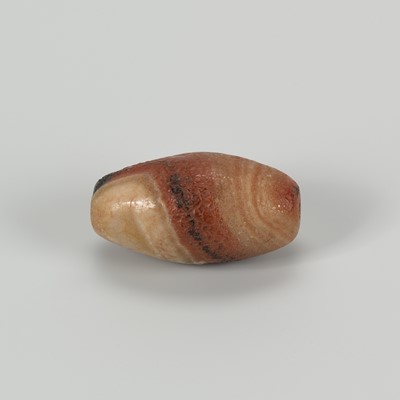 Lot 1524 - A HIMALAYAN BANDED AGATE BEAD, 19TH CENTURY OR EARLIER