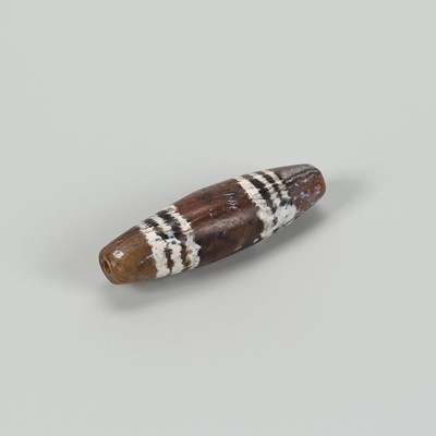 Lot 1509 - A FINE TIBETAN BANDED AGATE ‘CHUNG DZI’ BEAD, c. 500-1000 CE